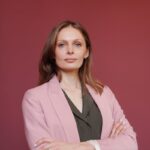 Femme d'affaires élégante avec les bras croisés dans un portrait en studio, mettant en valeur son leadership et sa confiance.