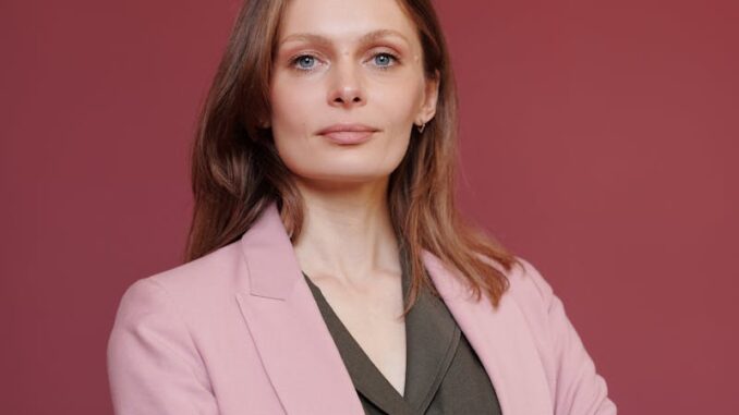 Femme d'affaires élégante avec les bras croisés dans un portrait en studio, mettant en valeur son leadership et sa confiance.