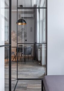 Chambre élégante dotée d'une cloison en verre, d'un mobilier moderne et d'une décoration artistique.