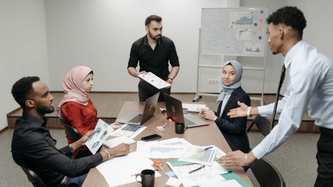 Une équipe de bureau diversifiée s'est engagée dans une réunion collaborative autour d'une table, discutant de stratégies commerciales.
