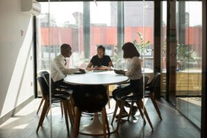 Trois professionnels collaborant dans une salle de réunion de bureau moderne pendant la journée.