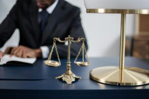Bureau juridique élégant avec un gros plan de la balance de la justice dorée sur un bureau sombre et élégant.
